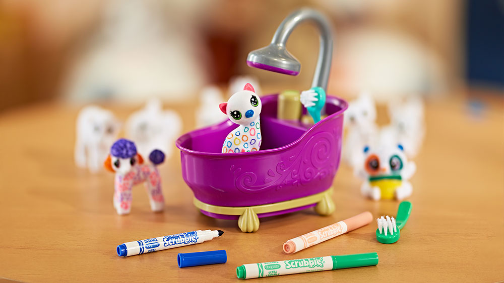 Cat scribble scrubbie in tub surrounded by assorted markers and scribble scrubbies.