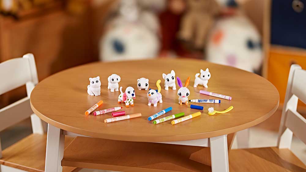 Assorted pets on table with scattering of washable markers.